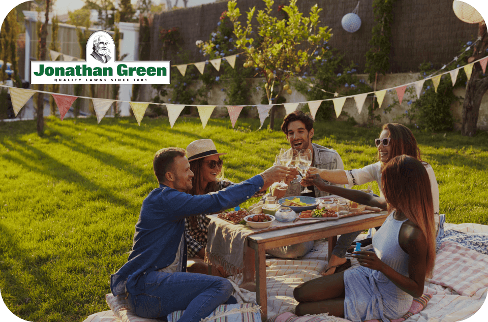 Friends enjoying an outdoor gathering with a Jonathan Green eGift Card toast at a sunlit picnic.