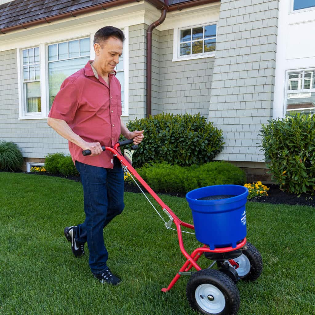 man-walking-deluxe-broadcast-spreader-lawn