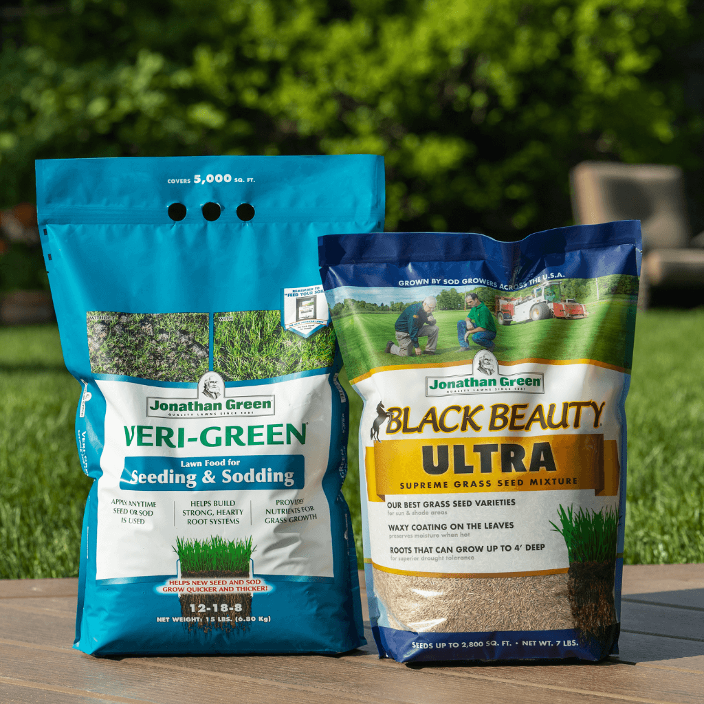Two bags of Jonathan Green grass seed, one labeled "Veri-Green" and the other "Black Beauty Ultra," form a Small Lawn Starter Kit, placed on grass in sunlight.