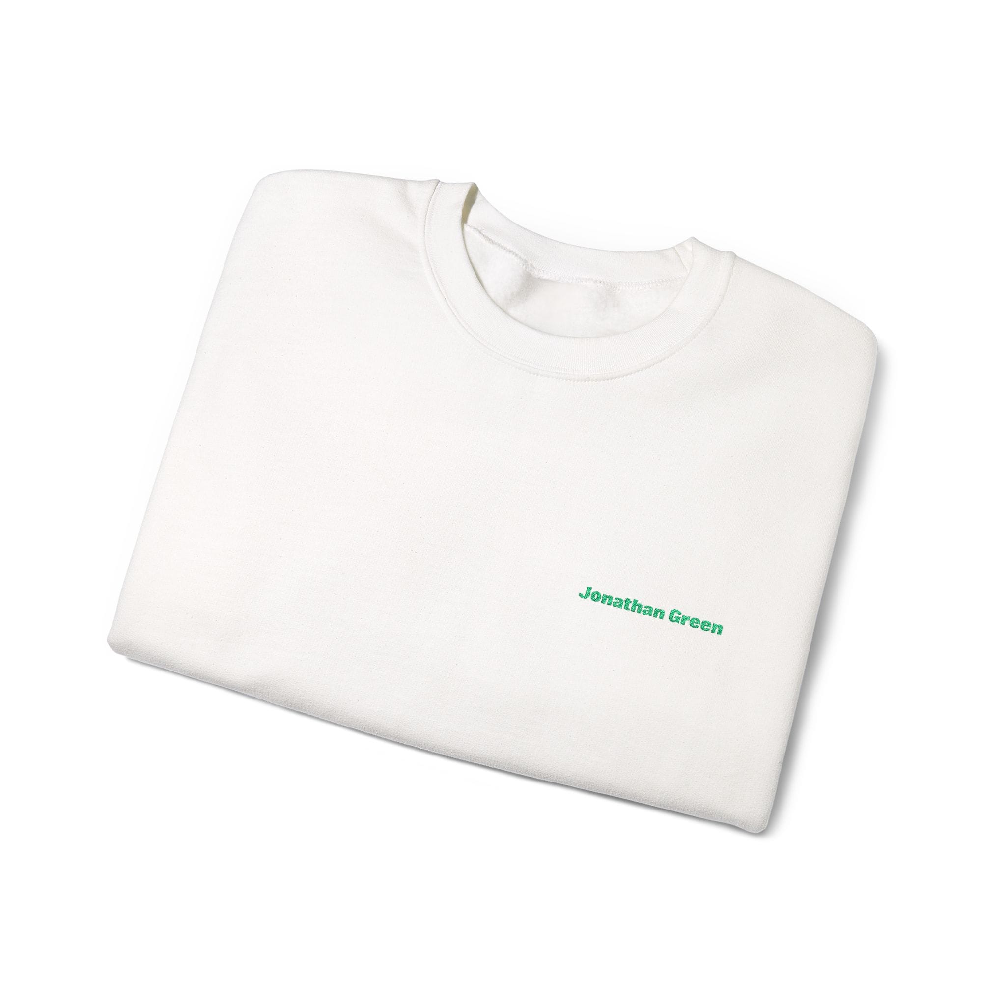 A folded white JG Embroidered Heavy Blend™ Crewneck Sweatshirt with "Jonathan Green" stitched in small green letters on the chest.
