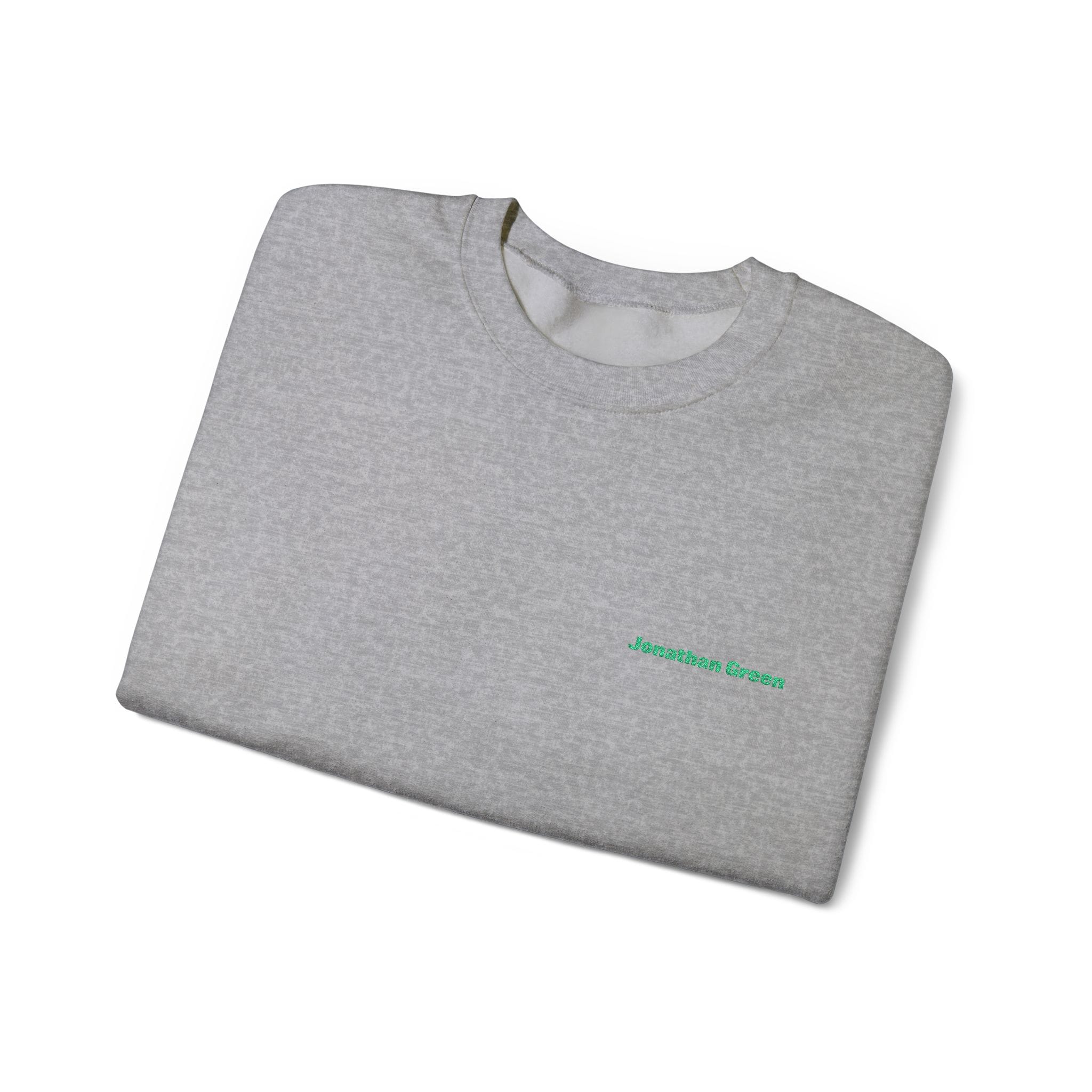 A folded light gray JG Embroidered Heavy Blend™ Crewneck Sweatshirt with "Jonathan Green" in green text on the left chest, displayed on a white background.