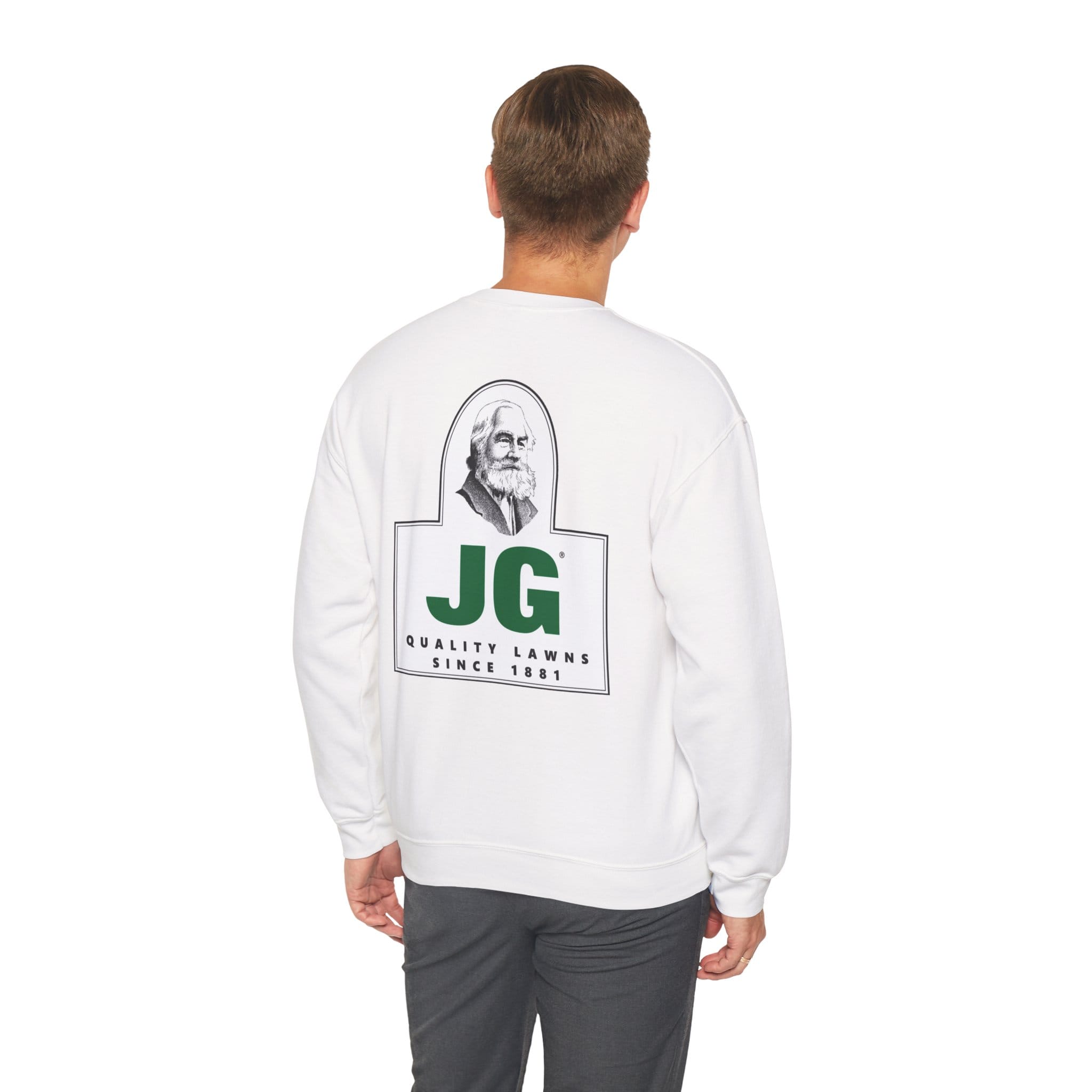 Someone models the JG Unisex Heavy Blend™ Crewneck Sweatshirt in white, featuring a bearded man graphic and "JG Quality Lawns Since 1981" on the back, against a plain white background.